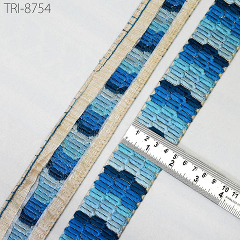a close-up view of a blue and white patterned fabric, with a ruler placed on top of it to measure its dimensions.