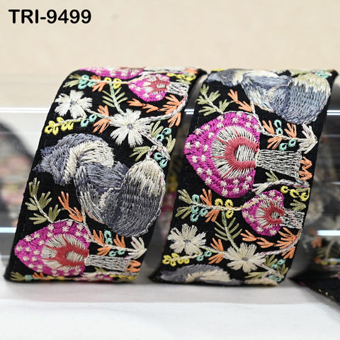 two decorative fabric pieces with intricate floral embroidery in various colors, including pink, white, and black. The pieces appear to be made of a soft, plush material and are displayed on a white surface.