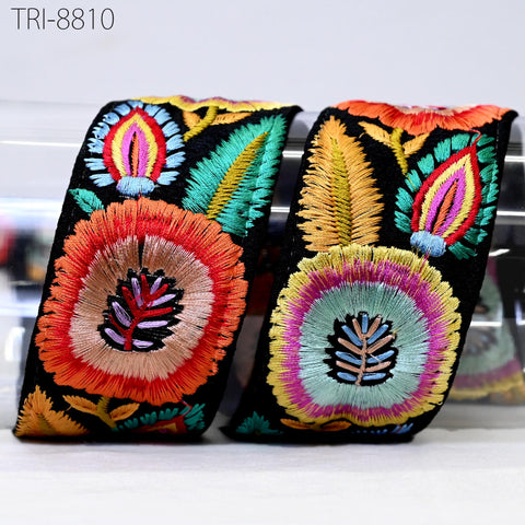 two colorful, intricately embroidered fabric pieces with a variety of floral and leaf designs.