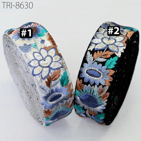 two rolls of fabric with colorful floral embroidery.