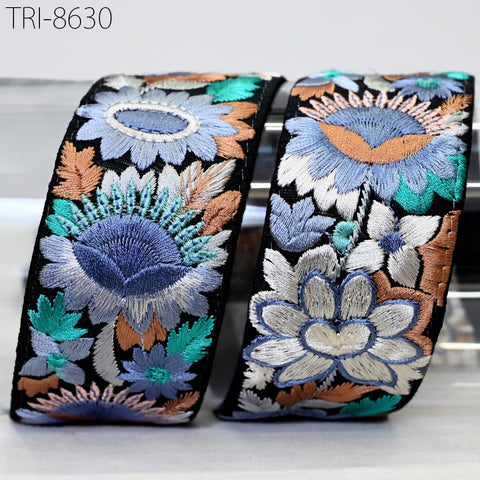 two decorative fabric pieces with intricate floral embroidery in various shades of blue, green, and orange.