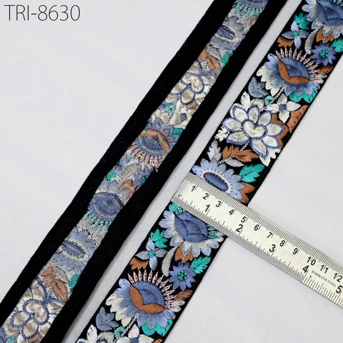 a close-up view of a decorative fabric with a floral pattern, featuring a ruler for scale.