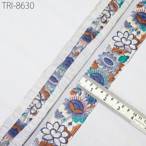 a close-up view of a decorative fabric with a floral pattern, featuring a ruler for scale.