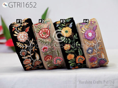 four colorful fabric pieces with intricate floral embroidery, arranged in a row on a table.