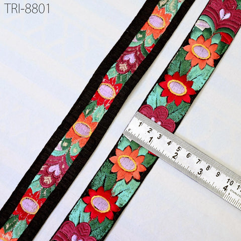 a close-up view of a decorative fabric with a floral pattern, featuring a ruler for scale.