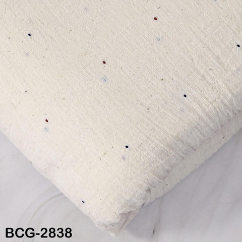 a close-up view of a white fabric with small red and blue dots scattered across it.