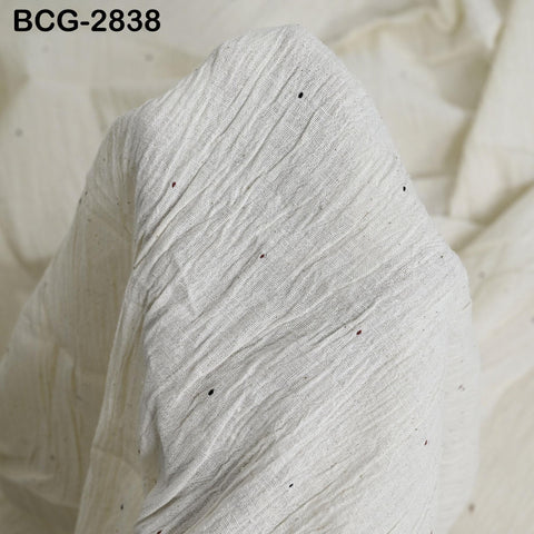 a close-up view of a white fabric with small black dots or specks on it.