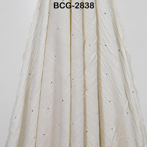 a close-up view of a white fabric with small black dots or specks on it.