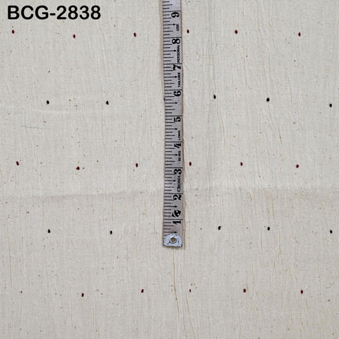 a ruler placed vertically on a white fabric with small dots on it, indicating measurements.