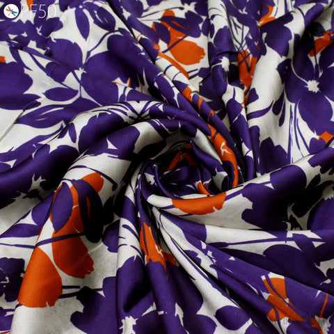a close-up view of a fabric with a floral pattern in shades of purple and orange. The fabric appears to be made of silk or a similar material, and it is crumpled and twisted in a way that creates a sense of movement and texture.