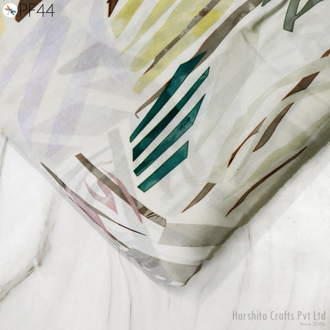 a close-up view of a fabric with a colorful abstract pattern, featuring various shades of green, yellow, and brown.