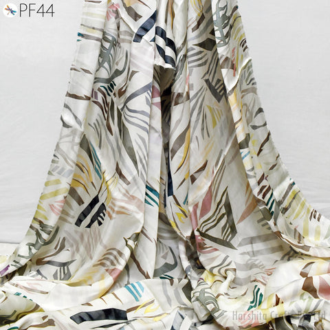a colorful, patterned fabric with a mix of geometric and organic shapes, including stripes, swirls, and floral designs. The fabric appears to be made of silk or a similar material, and it is folded or draped in a way that showcases its intricate patterns and textures.