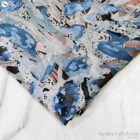 a close-up view of a fabric with a colorful abstract pattern, featuring various shades of blue, pink, and black.