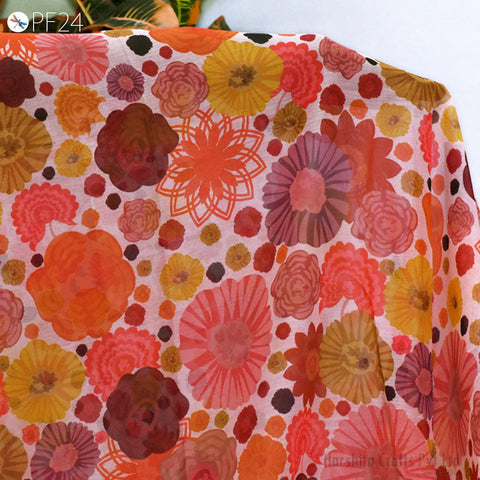 a vibrant and colorful fabric with a repeating pattern of various flowers in shades of pink, orange, and yellow.