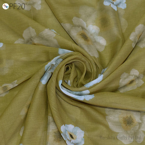 a close-up view of a fabric with a floral pattern, featuring white and green flowers. The fabric appears to be made of a soft, light-colored material, possibly cotton or linen.