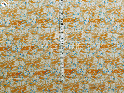 a close-up view of a fabric with a floral pattern, featuring a ruler for scale.