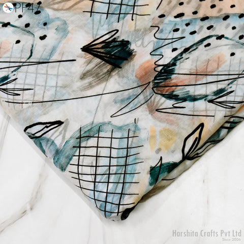 a close-up view of a fabric with a colorful abstract pattern, including various shapes and lines in shades of blue, green, and orange.