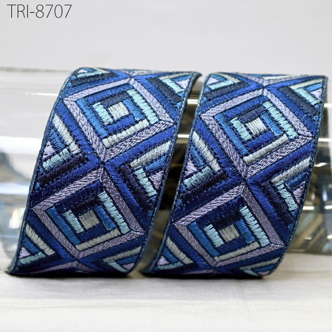 two pieces of fabric with a geometric pattern in shades of blue and purple. The pattern consists of diamond shapes arranged in a repeating diagonal pattern. The fabric appears to be made of a soft, plush material, possibly cotton or a similar natural fiber.