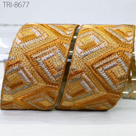 two ornate gold and silver embroidered pieces, with intricate geometric patterns and designs.