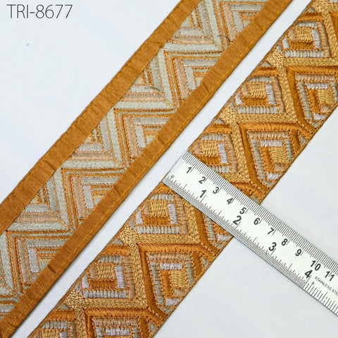 a close-up view of a decorative fabric with a geometric pattern, featuring a ruler for scale.