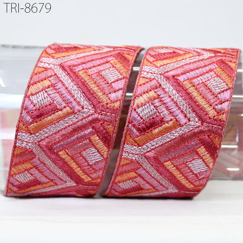 two pieces of red and orange embroidered fabric, with a geometric pattern. The fabric appears to be a decorative item, possibly used for clothing or home decor.