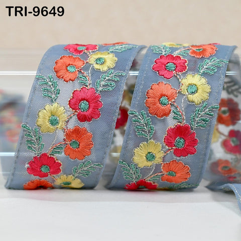 a decorative fabric with a floral pattern, including red, yellow, and orange flowers arranged in a repeating design.