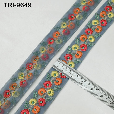 a decorative fabric with a floral pattern, featuring a ruler placed on top of it to measure its length.