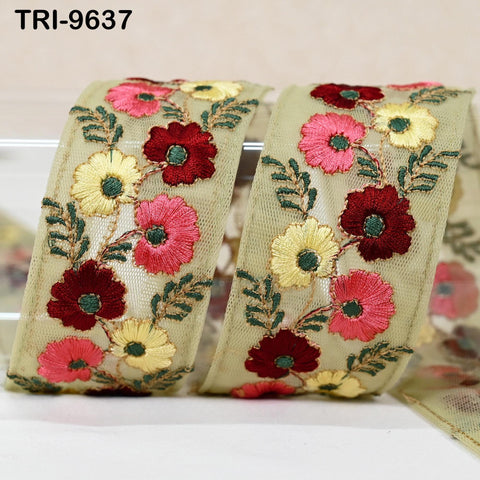 a decorative fabric with a floral pattern, including red, yellow, and pink flowers, as well as green leaves. The fabric appears to be a ribbon or a piece of cloth with a floral design.