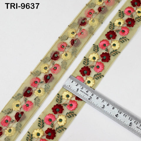 a decorative fabric with a floral pattern, including red, yellow, and pink flowers, and green leaves. A ruler is placed next to the fabric, indicating the size of the fabric.