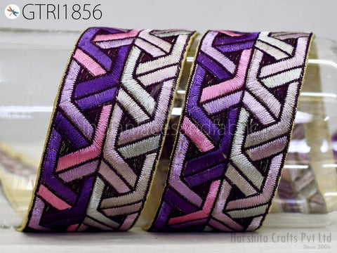two decorative fabric pieces with a geometric pattern in shades of purple, pink, and white.
