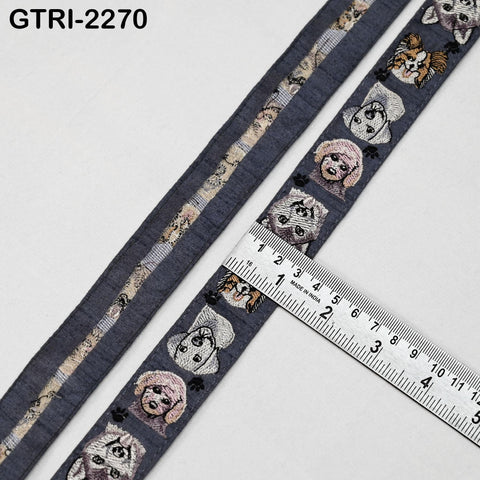 a gray fabric with a repeating pattern of cartoon-like dog faces, and a ruler is placed on top of the fabric to measure its length.