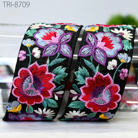 two decorative fabric pieces with a floral pattern in shades of red, purple, and green. The fabric appears to be black with colorful floral designs.