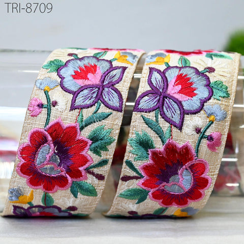 two decorative fabric pieces with intricate floral embroidery in various colors, including red, blue, and purple.