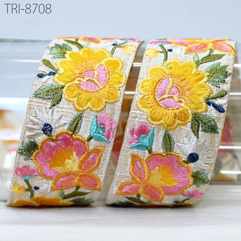 two decorative fabric pieces with a floral pattern, including yellow and pink flowers, placed on a white surface.