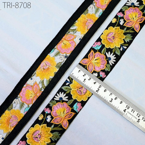 a close-up view of a decorative fabric with a floral pattern, featuring a ruler for scale.