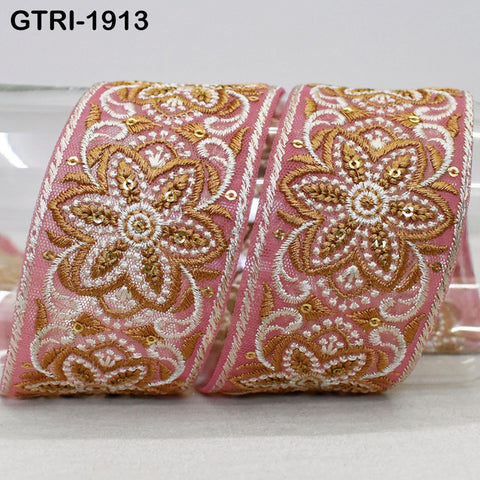 two decorative fabric pieces with intricate floral patterns in shades of pink and gold. The pieces appear to be made of a shiny, embroidered material and are displayed against a plain background.