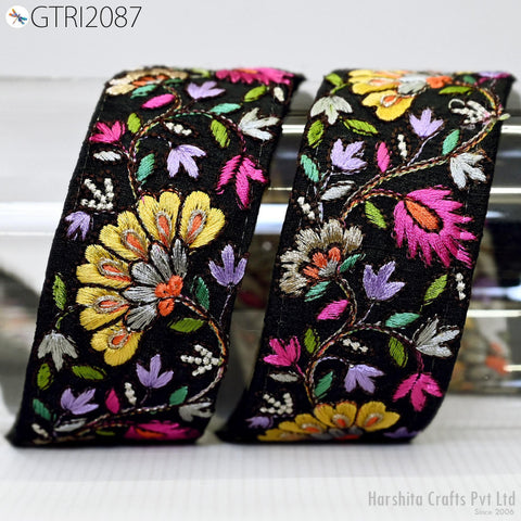two decorative fabric pieces with a floral pattern in black, yellow, and pink colors. The fabric appears to be made of silk and is displayed on a white surface.