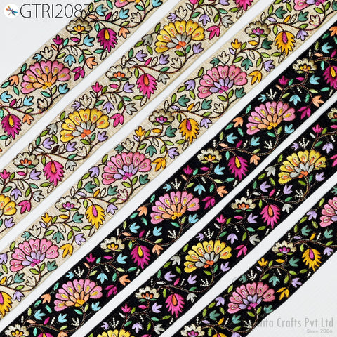 a collection of colorful, intricately embroidered fabric pieces with floral patterns. The fabric pieces are arranged in a diagonal pattern, showcasing a variety of vibrant colors and designs.