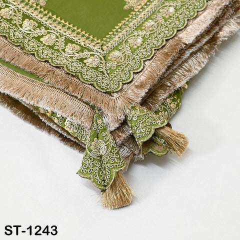 a close-up view of a decorative green and gold fabric with intricate embroidery and fringe details.