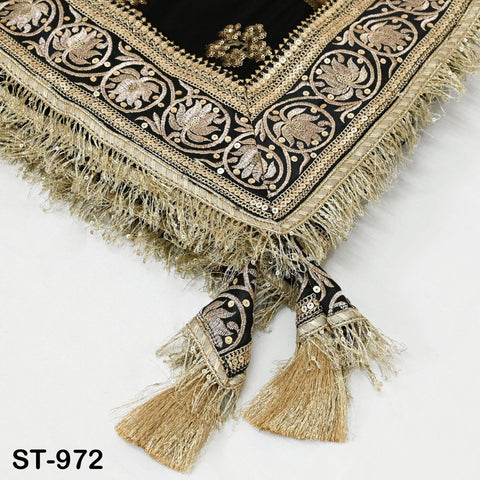 a decorative fabric with intricate gold and black embroidery, featuring a floral pattern and fringe details. The fabric appears to be a textile or textile-like material, possibly used for clothing or home decor.
