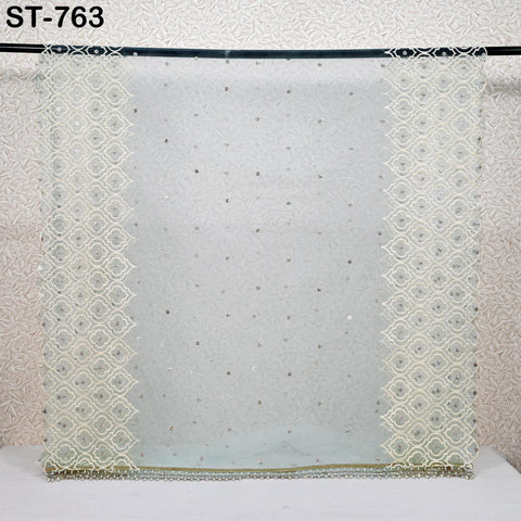 a white fabric with a repeating pattern of small white dots or circles, creating a textured and decorative appearance.