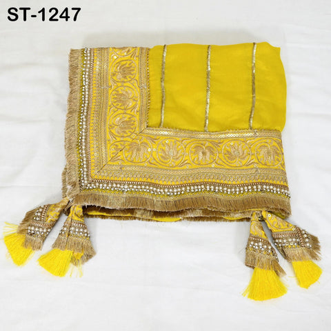 a yellow and gold embroidered fabric with a decorative border, featuring a floral pattern and tassels.