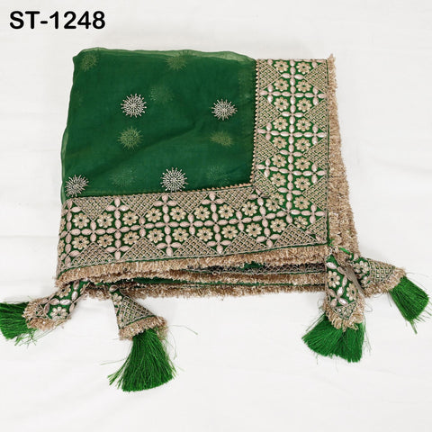 a green and gold embroidered fabric with a floral pattern and tassels.