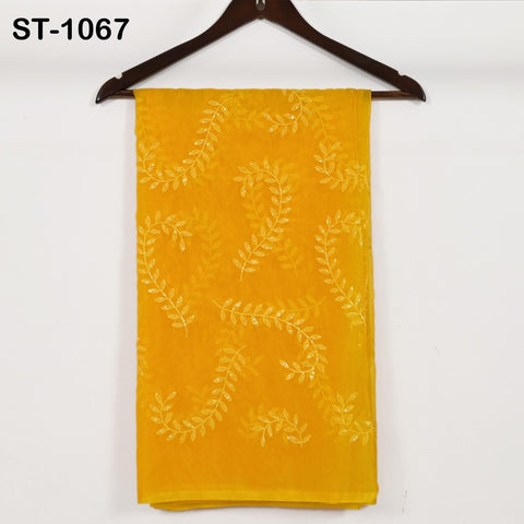 a yellow fabric with a leaf pattern, hanging on a wooden hanger against a white background.