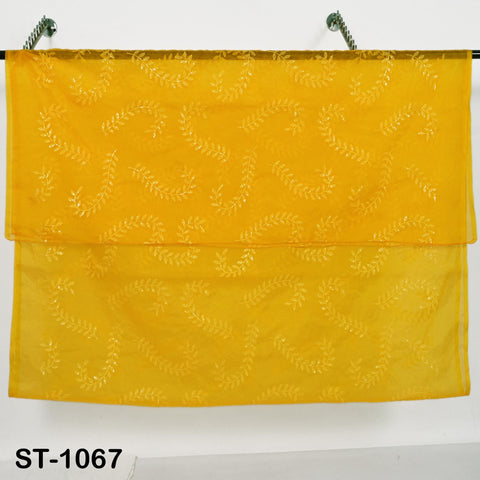 a yellow fabric with a leaf pattern, hanging on a hook.
