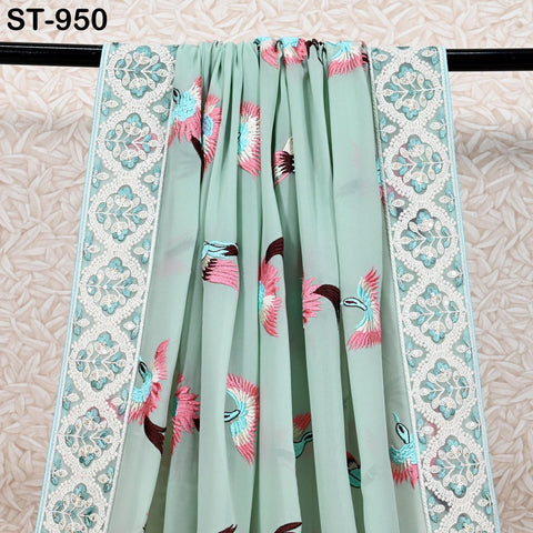 a light green fabric with a floral pattern and a white border. The fabric has a repeating pattern of pink and blue birds, and the border is decorated with a white lace-like design.