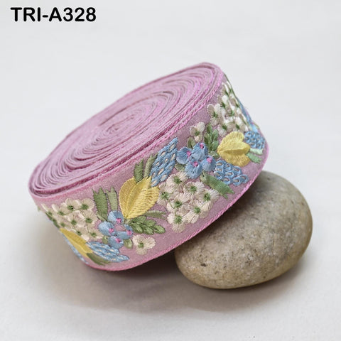 A pink fabric with a floral pattern is placed on a rock.