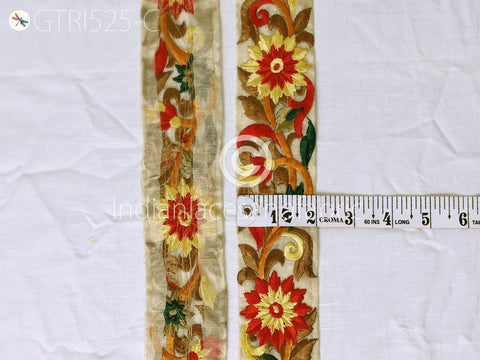 two pieces of fabric with intricate floral embroidery, and a ruler is placed next to them to provide a size reference.