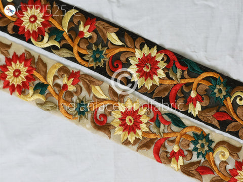 two decorative fabric pieces with intricate floral embroidery. The left piece is predominantly red and yellow, while the right piece is black and gold. The two pieces are arranged diagonally, creating a visually appealing contrast between the vibrant colors and the neutral background.