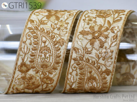 two ornate gold and white embroidered ribbons with intricate floral designs.